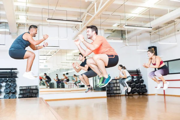 Comprimento Total Treinador Masculino Fazendo Saltos Tuck Com Clientes Health — Fotografia de Stock