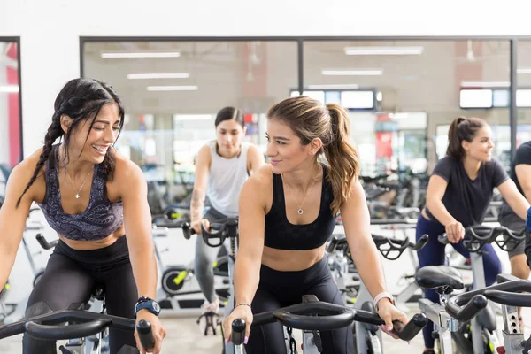 Des Clientes Souriantes Faisant Vélo Appartement Regardant Ailleurs Dans Club — Photo