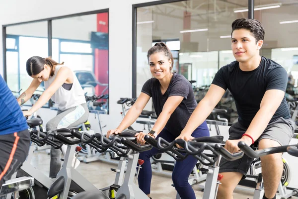 Cliente Varón Seguro Sonriendo Mientras Hace Ejercicio Bicicleta Con Amigos — Foto de Stock