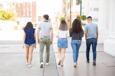 Beş genç çocukların kaldırmalı ve kız açık havada yürümek şehir sokak bac Grup