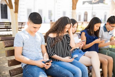 Yakışıklı genç çocuk cep telefonuyla arkadaşlarınızla kendi sosyal medya durum güncelleme meşgul oturan