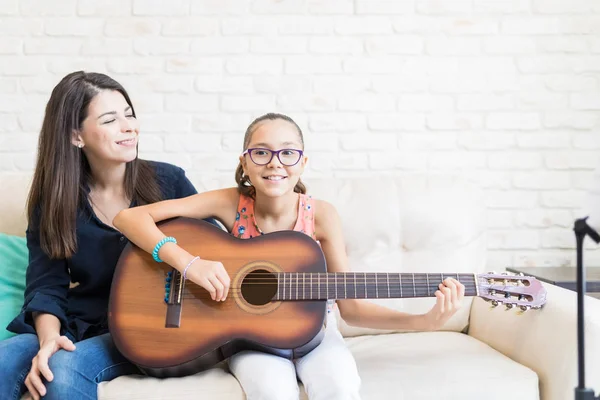 Happy Girl Showing Guitar Skills Female Teacher While Sitting Sofa — Stock Photo, Image