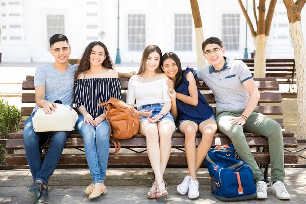 Ritratto Gruppo Cinque Amici Adolescenti Seduti Sulla Panchina Che Guardano — Foto Stock