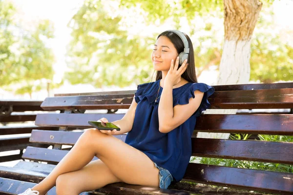 Bastante Chica Adolescente Latina Usando Auriculares Escuchando Música Mientras Sienta —  Fotos de Stock