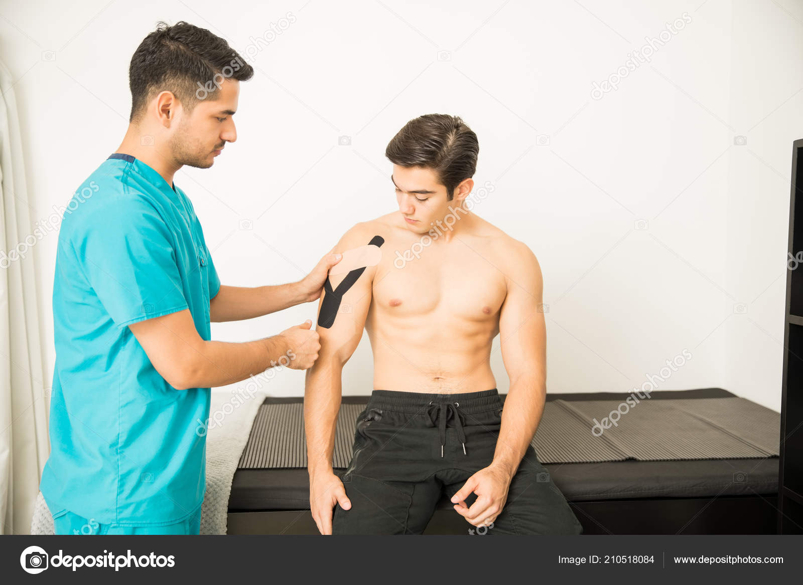 Young Physical Therapist Placing Kinesiology Tape Shoulder Athlete