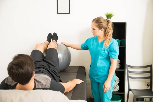 Vrouwelijke Fysiotherapie Specialist Bijstaan Van Mens Uit Oefenen Met Behulp — Stockfoto