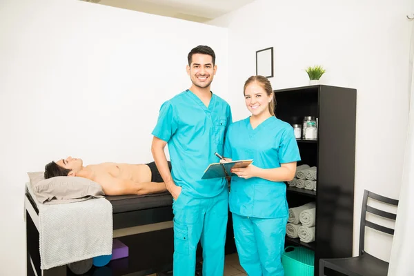 Profesionales Jóvenes Fisioterapia Con Portapapeles Pie Por Paciente Cama Hospital — Foto de Stock