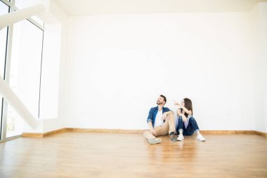 yeni evinde otururken adama bir şey gösterilen kadın