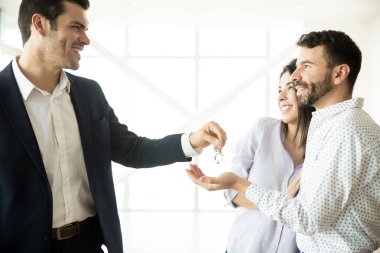 Mutlu orta yetişkin çift tuşları yeni dairede aracısından alma