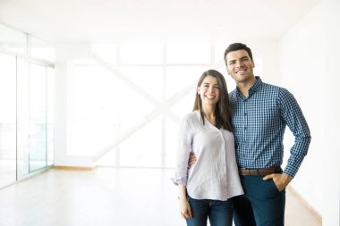 Çift ayakta kol çevresinde yeni ev gülümseyen portresi