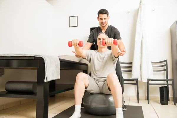 Spécialiste Physiothérapie Aidant Homme Âgé Assis Sur Une Balle Exercice — Photo
