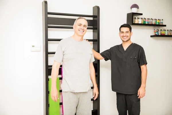 Retrato Fisioterapeuta Confiado Paciente Maduro Sonriendo Contra Las Barras Pared —  Fotos de Stock