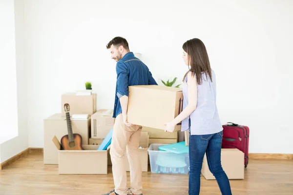 Woman Assisting Man Carrying Heavy Box While Moving House — Stock Photo, Image