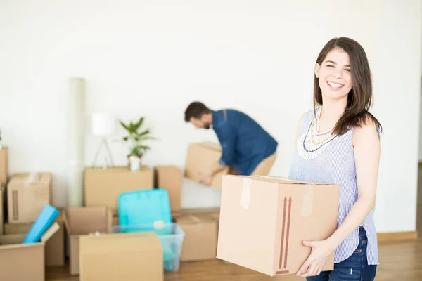Glückliche Frau Trägt Schachtel Während Mann Hintergrund Arrangement Neuen Zuhause — Stockfoto