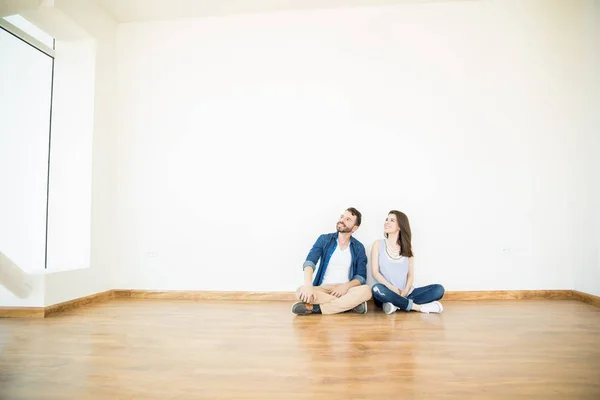新居で床に座っている間は離れている男性と女性の所有者 — ストック写真