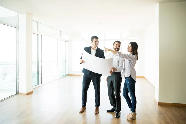 Gelukkig Woman Wijzend Weg Terwijl Door Man Agent Bespreken Blauwdruk — Stockfoto