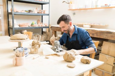 Orta yetişkin usta clay doll atölyesinde heykel aracını kullanarak yapma