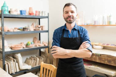 Atölyede önlük giyiyor yetişkin çanak çömlek yapımcısı orta emin