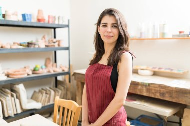 Kendine güvenen kadın esnaf Çanak Atölyesi önlük giyen portresi