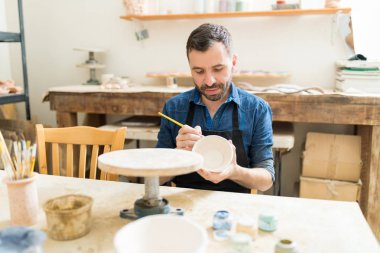Erkek Sanatçı kil kase Studio masada boya ile dekorasyon