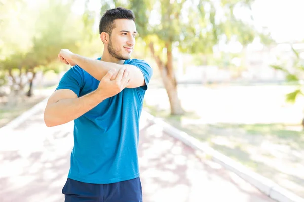 Bonito Corredor Masculino Esticando Braço Antes Treino Parque — Fotografia de Stock