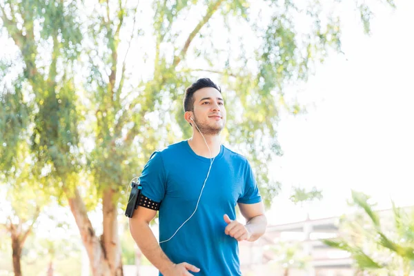 Gesunder Junger Mann Hört Musik Über Kopfhörer Beim Joggen Park — Stockfoto