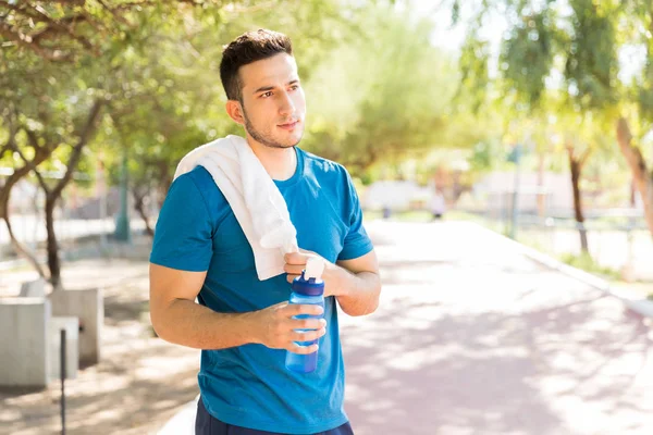 Düşünceli Atletik Erkek Holding Şişesi Yaz Aylarında Parkta Egzersiz Sonrası — Stok fotoğraf