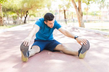 Koşu parkuru Park ısınma sırasında ayak dokunmak esnek sportif adamın tam uzunlukta