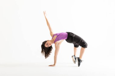 Geriye doğru düz arka plan üzerinde bükme kolu kendine güvenen kadın dansçı kaldırdı