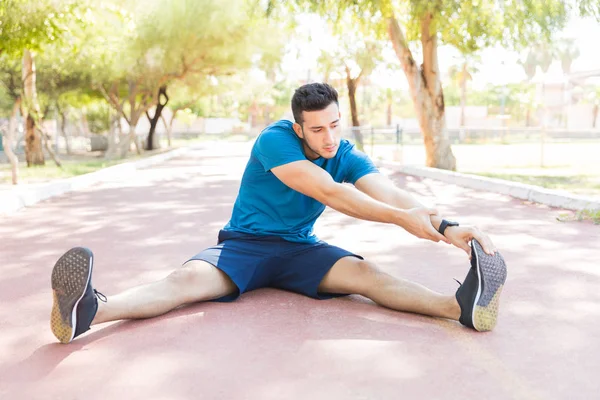 Fit Νεαρός Αθλητής Κάνει Τεντώνοντας Άσκηση Πριν Από Αγώνα Στην — Φωτογραφία Αρχείου