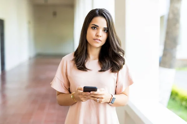 Confident Female Chatting Online Using Mobile Phone While Standing Corridor — Stock Photo, Image