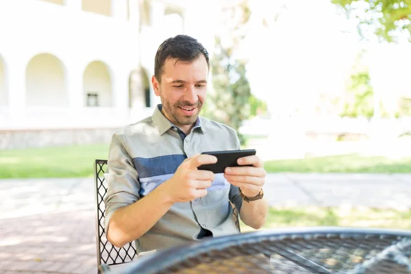 Χαμογελώντας Μέσα Του Ενήλικα Άνδρα Παίζοντας Παιχνίδια Στο Smartphone Ενώ — Φωτογραφία Αρχείου