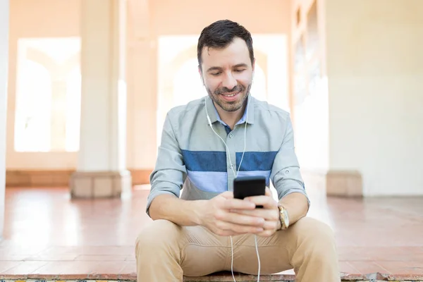Smiling Male Using Radio Listen Music Smartphone While Sitting Corridor — Stock Photo, Image