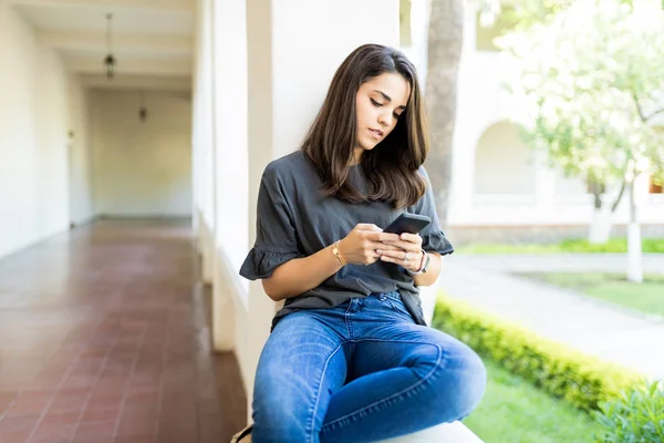 Yetişkin Kadın Korkuluk Üzerinde Otururken Cep Telefonu Ile Ilgili Notlar — Stok fotoğraf