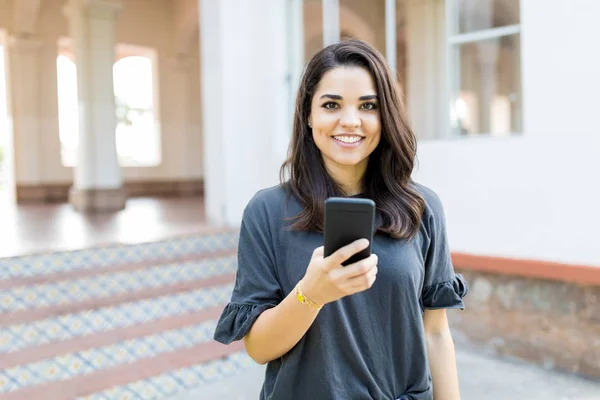 Portrait Smiling Woman Holding Smartphone While Standing Building — Stock Photo, Image