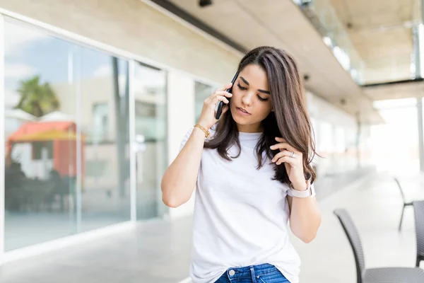 中年妇女在购物中心听她的移动电话电话 — 图库照片