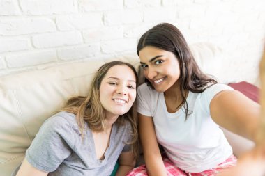 Pijama selfie için evde poz gülümseyen genç kadın portresi