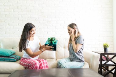 Hediye kutusu oturma odasında heyecan en iyi arkadaşına gülümseyen kadın