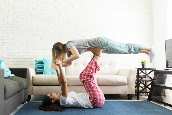 Energetico Femminile Sollevamento Migliore Amica Con Piedi Mentre Sdraiato Tappeto — Foto Stock