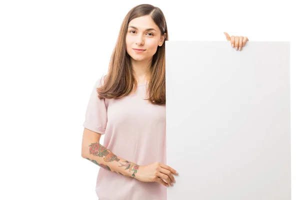 Junge Frau Hält Leere Werbetafel Während Sie Vor Weißem Hintergrund — Stockfoto