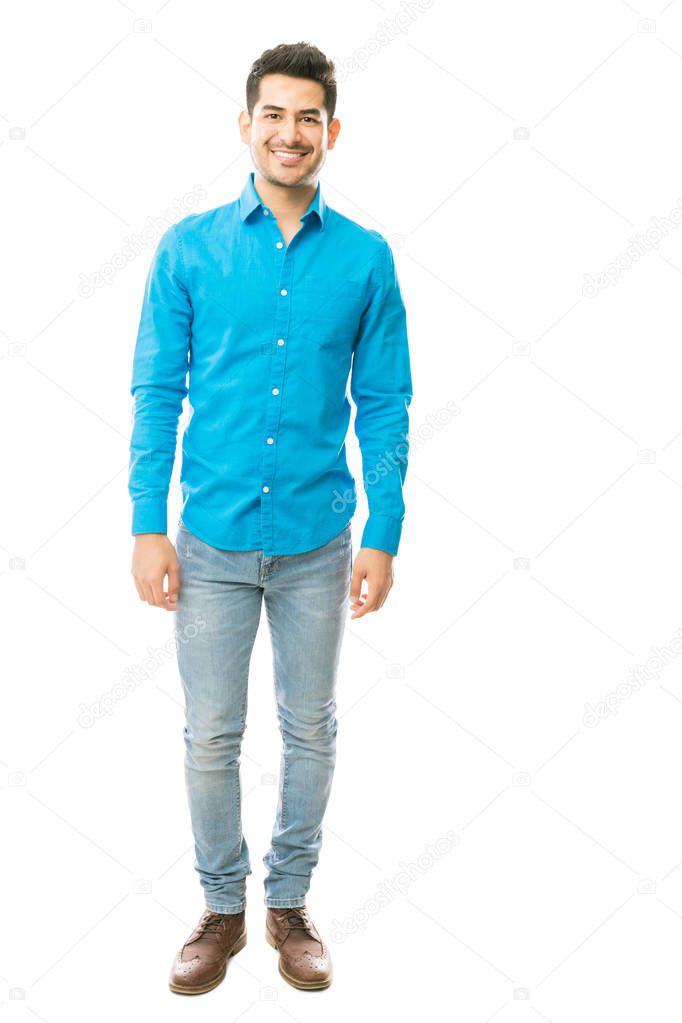Full length portrait of attractive young male in casuals standing against white background