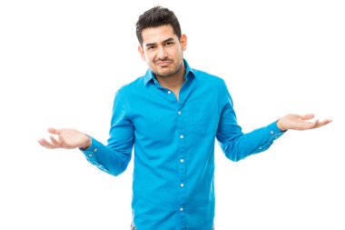 Beyaz arka plan üzerinde onun omuzlarında shrugging ise mavi gömlek giymiş emin adam portresi