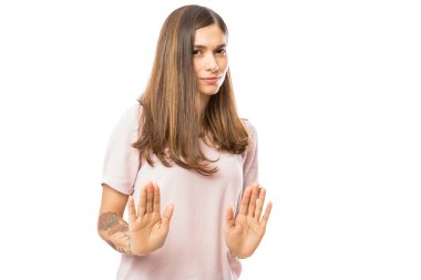 Portrait of young brunette woman expressing denying against white background clipart
