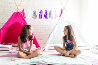 Preteen kızlar birbirine pijama partisi sırasında teepee çadır karşı otururken bakarak