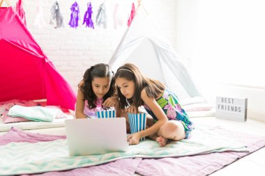 Şirin kızlar film üstünde laptop evde pijama partisi sırasında patlamış mısır yaparken zevk