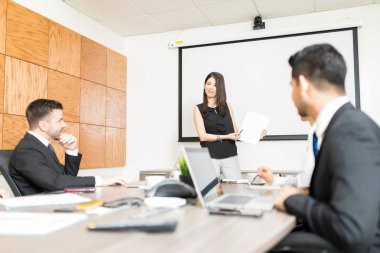 Kendine güvenen girişimci iş ortaklarıyla Office belgesi üzerinde tartışıyor