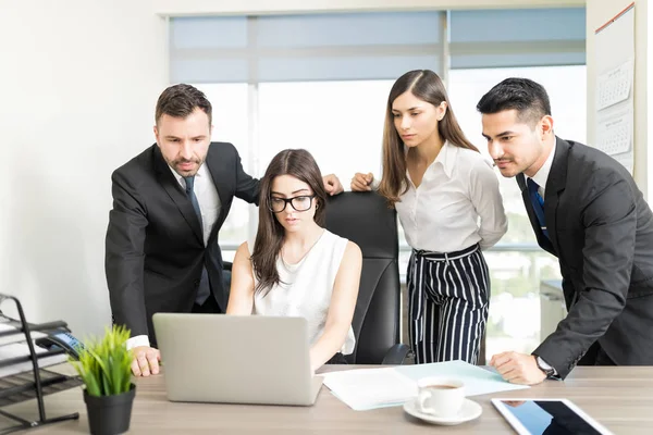 Successful business team planning work on laptop at meeting in office