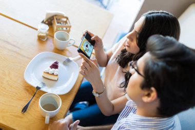 Cazip cheesecake adam kafede kalma sırasında fotoğraf çekimi kadın