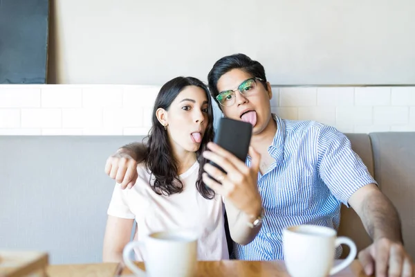 Humorous Lovers Taking Pictures While Sticking Out Tongue Coffee Shop — Stock Photo, Image