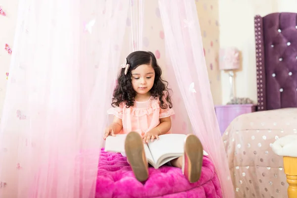 Comprimento Total Livro Leitura Bonito Menina Enquanto Sentado Otomano Seu — Fotografia de Stock